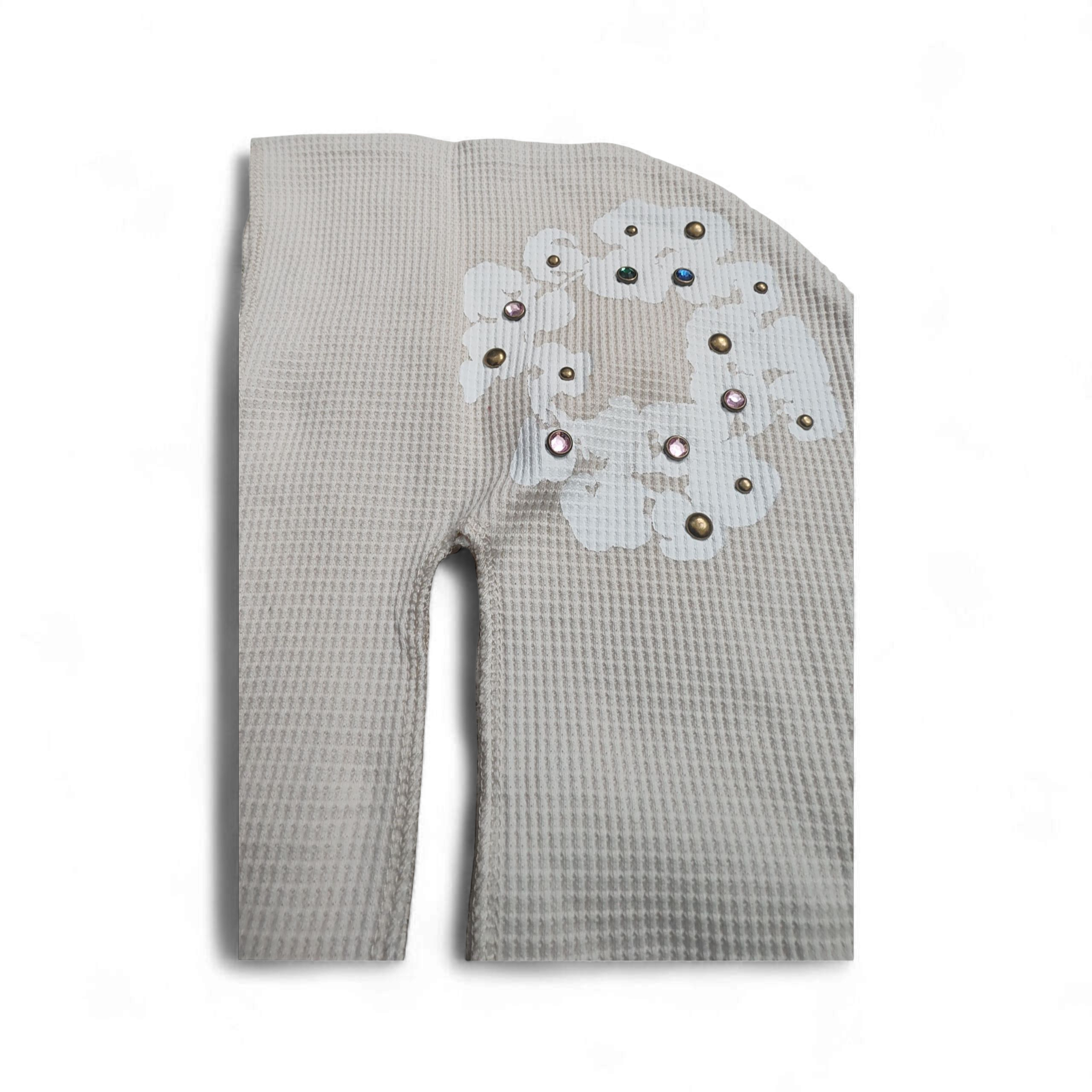 Oatmeal textured Denim Tears with a decorative patch on a white background